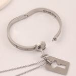 Submissive bracelet - Close-up of stainless steel BDSM bracelet with key pendant on wrist