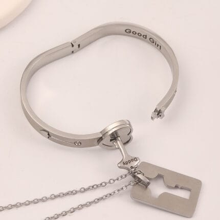 Submissive bracelet - Close-up of stainless steel BDSM bracelet with key pendant on wrist