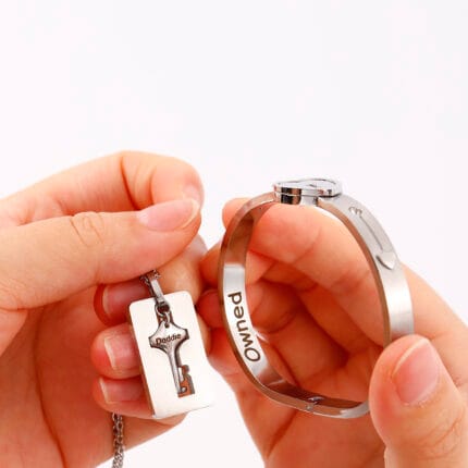 Couples lock key bracelet set engraved with “Good Girl.” Symbolic, permanent locking jewelry for submissives and Dominants in D/s relationships.