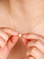 Gold discreet BDSM necklace with pearl for submissives, shown as elegant day collar jewelry.