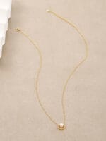 Gold discreet BDSM necklace with pearl for submissives, shown as elegant day collar jewelry.