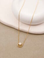 Gold discreet BDSM necklace with pearl for submissives, shown as elegant day collar jewelry.