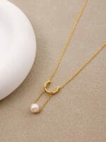 Gold discreet BDSM necklace with pearl for submissives, shown as elegant day collar jewelry.