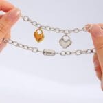 Lockable BDSM collar with silver chain, dual heart charms, and engraved hex lock clasp