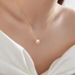 Gold discreet BDSM necklace with pearl for submissives, shown as elegant day collar jewelry.