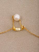 Gold discreet BDSM necklace with pearl for submissives, shown as elegant day collar jewelry.