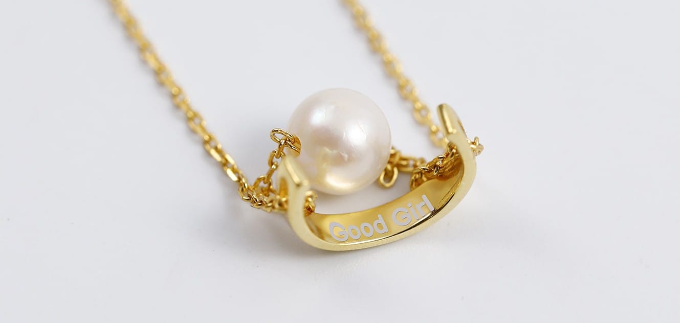 Gold submissive pearl necklace engraved with “Good Girl” — symbol of elegance, praise, and quiet power.
